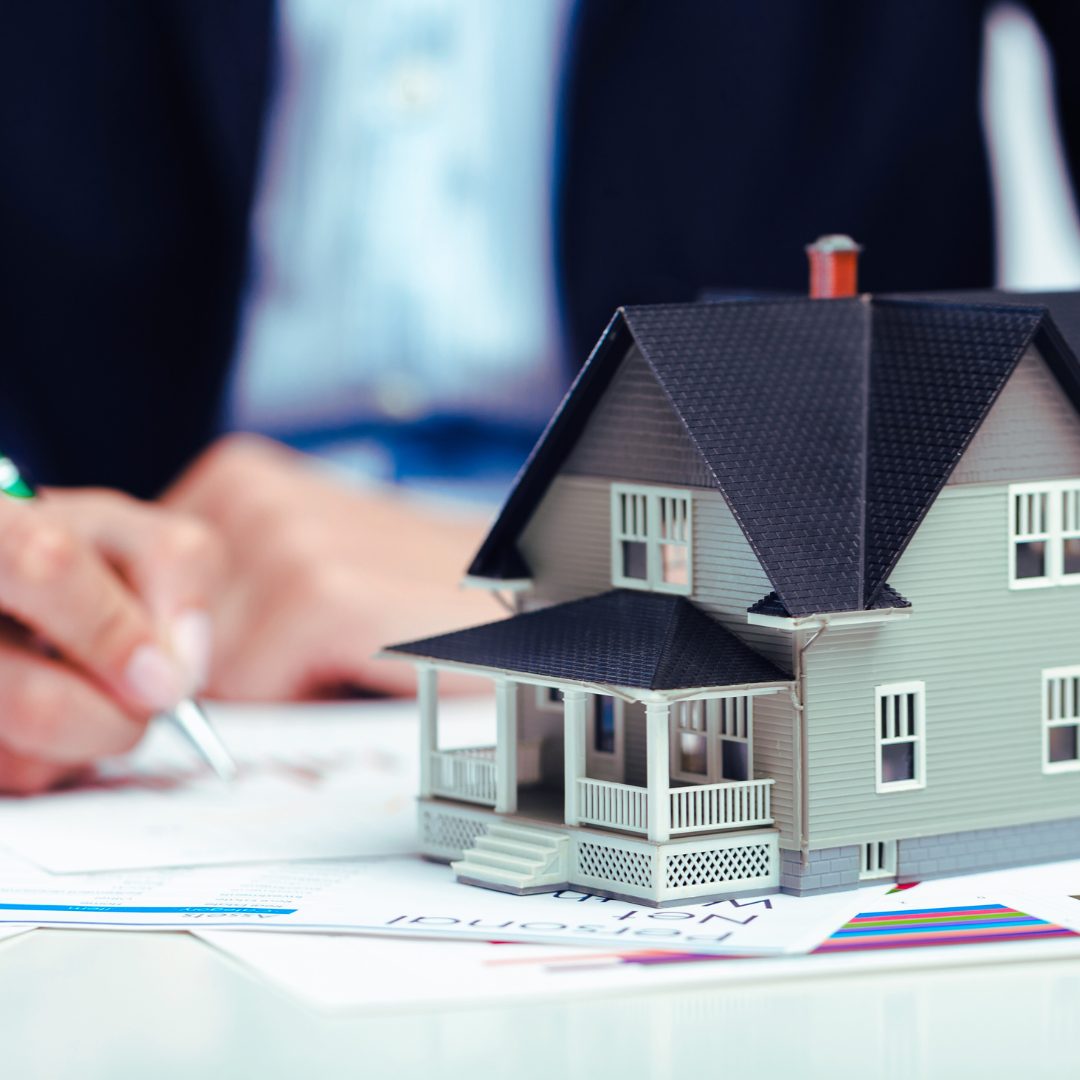 Realtor at closing table with a small house on desk Alan Fishman Coldwell Banker Realty Franklin County PA