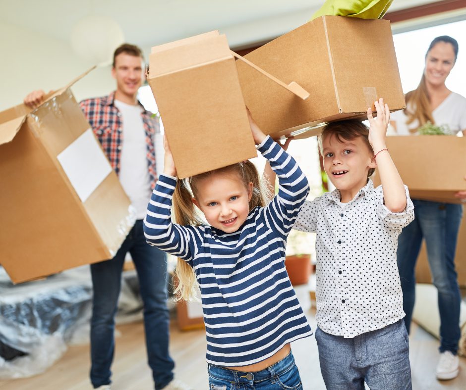 Family with kids holding moving boxes Alan Fishman Coldwell Banker Realty Franklin County PA